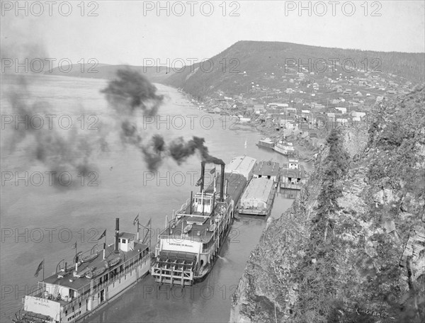 Riverboats distant view of town, between c1900 and 1923. Creator: Unknown.