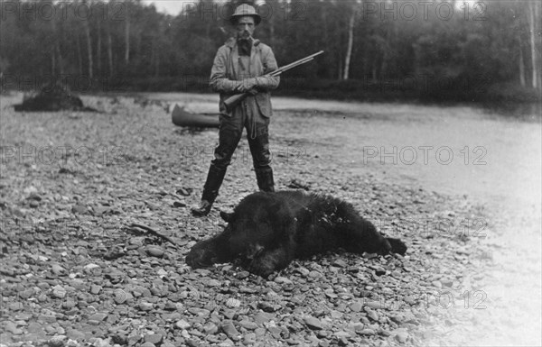 Hunter with bear which he killed, between c1900 and 1927. Creator: Unknown.