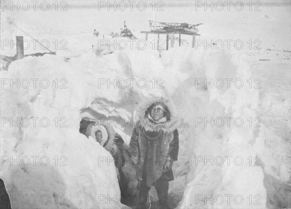 Alaskan Eskimos with their winter home half underground in village of Stebbins, c1900- c1930. Creator: Unknown.