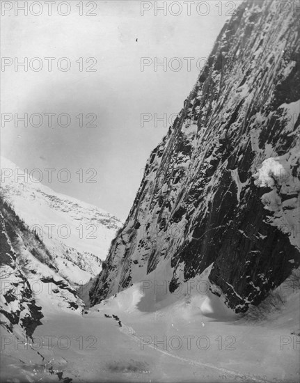 Men traveling with horses through snow covered valley, between c1900 and c1930. Creator: Unknown.