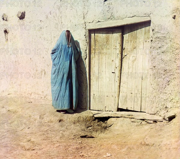 Woman in purdah, standing near wooden door, between 1905 and 1915. Creator: Sergey Mikhaylovich Prokudin-Gorsky.