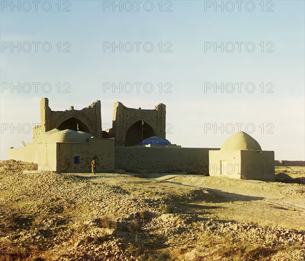 Walled adobe structure with domes and arches in desert area, with man posed..., between 1905-1915. Creator: Sergey Mikhaylovich Prokudin-Gorsky.