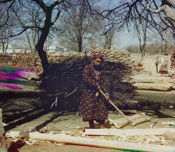 Man using tool to strip logs, Central Asia?, between 1905 and 1915. Creator: Sergey Mikhaylovich Prokudin-Gorsky.