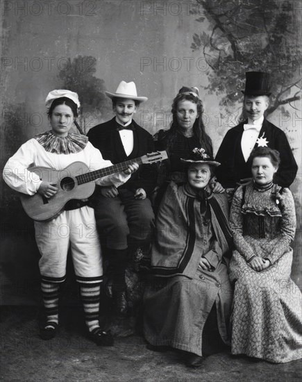 Six dressed-up youngsters, one of the young people plays the guitar, 1910-1920. Creator: Hans Per Persson.