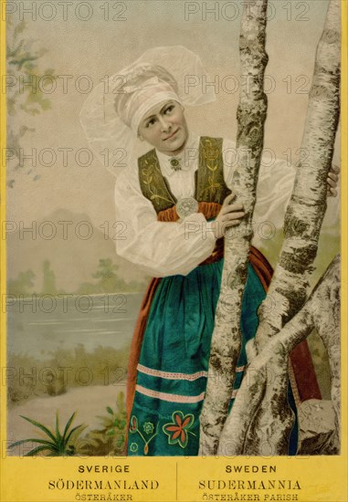 Coloured portrait photograph of a woman looking out from behind birch trunks, 1870-1900.  Creator: Unknown.