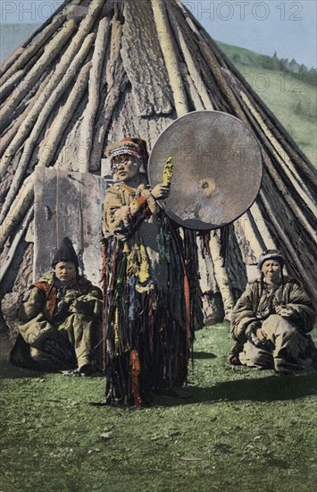 Altai Shaman with Tambourine in Front of a Traditional Dwelling (Chaadyr), 1911-1913. Creator: Sergei Ivanovich Borisov.