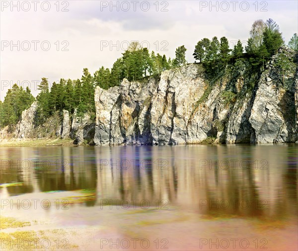 Shaitan Rock; general view from the village of Novaia Derevnia, Chusovaya River, 1912. Creator: Sergey Mikhaylovich Prokudin-Gorsky.