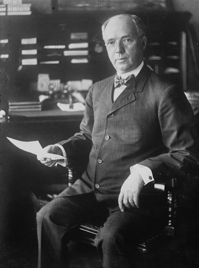J.D. Archbold, seated holding paper, 1911. Creator: Bain News Service.