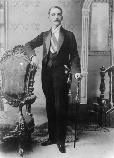 C.E. Restrepo posing next to chair, with cane, 1910. Creator: Bain News Service.