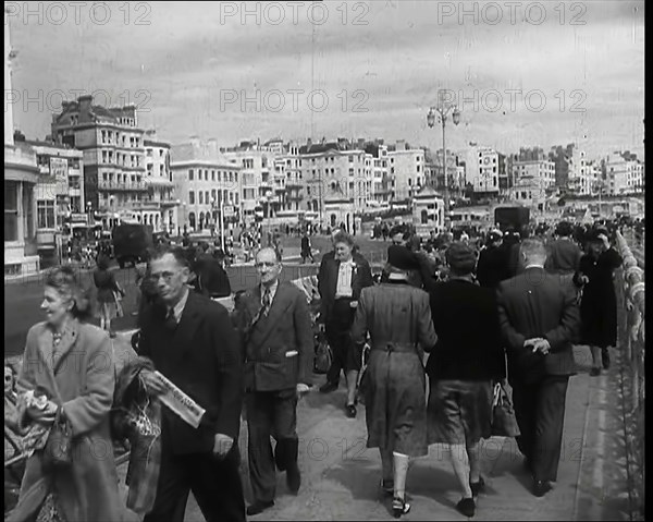 A Cloudy Day as Male and Female Pedestrians are Walking on the Promenade at Brighton..., 1939. Creator: British Pathe Ltd.