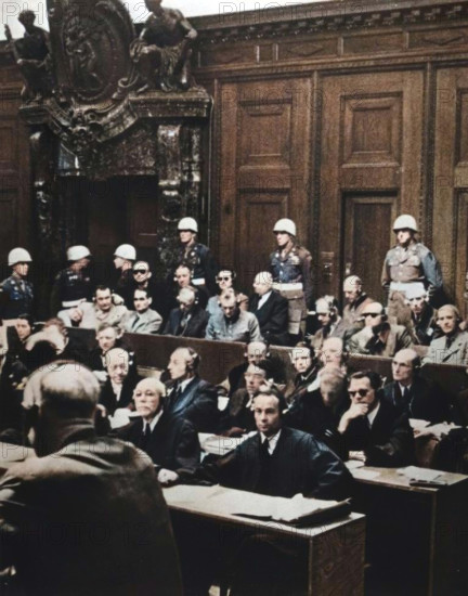 Nuremberg war crimes trial, Germany, 1946. Between 20 November 1945 and 1 October 1946 the 24 surviving most senior Nazi leaders were tried before the International Military Tribunal in the Palace of Justice in Nuremberg. The defendants pictured are as follows. Back row (left to right): Admiral Karl Doenitz, Admiral Erich Raeder, Baldur von Schirach (leader of the Hitler Youth), Fritz Sauckel (head of the Nazi slave labour programme), General Alfred Jodl, Franz von Papen. Front row (left to right): Hermann Goering, Rudolf Hess, Joachim von Joachim von Ribbentrop (Foreign Minister), Field Marshal Wilhelm Keitel, Alfred Rosenberg, Hans Frank (ruler of occupied Poland), Wilhelm Frick (Interior Minister). Von Papen was acquitted, Doenitz, Raeder, von Schirach and Hess received prison terms (the latter for life) and the remainder were sentenced to death. (Colorised black and white print).