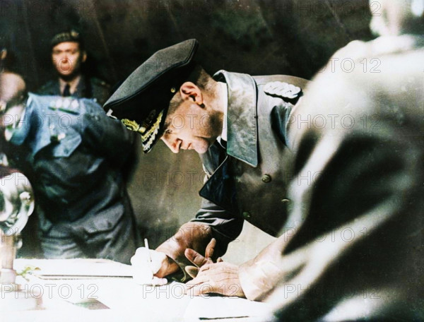 Rear-Admiral Gerhard Wagner signing the German surrender document ending World War II, 1945. (Colorised black and white print).