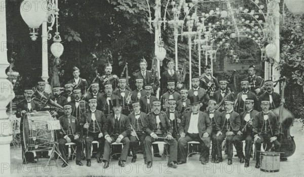 The London Military Band at Kroll's Garden in Berlin, Germany, 1896. Group portrait of British musicians in a beer garden. Instruments include: bagpipes, drums, clarinets, trumpets and a double bass.