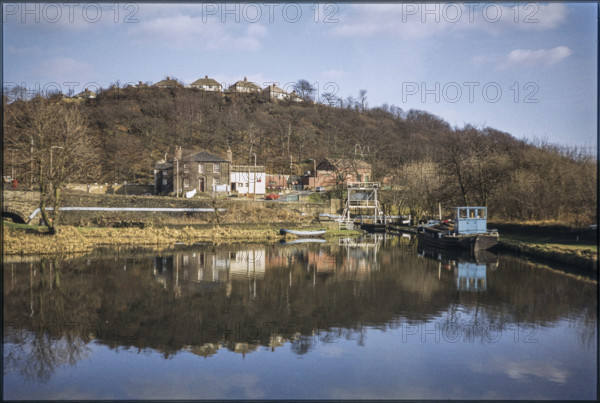 The view looking east across Salterhebble Low Basin on the Calder and Hebble Navigation, Salterhebble Low Basin, Halifax, 1980; with the Calder and Hebble Inn (now demolished) beyond the basin and homes on Chevinedge Crescent in the background.