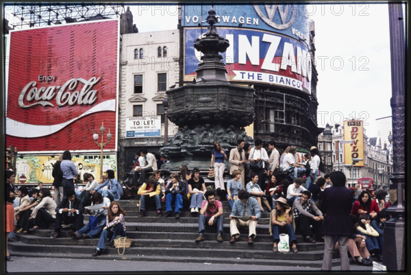 Crowds on the steps at the base of the Shaftesbury Memorial Fountain, or Eros, at Piccadilly Circus, London, 1974.