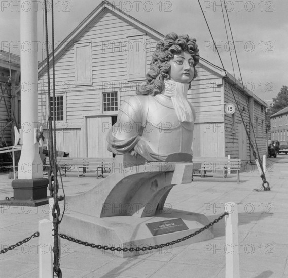 General view of a figurehead from HMS Benbow outside Boat House number 5 at Portsmouth Naval Dockyard, 1956.