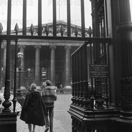 Visitors around the wrought iron gates at the south entrance to the British Museum, London, 1962-1965.