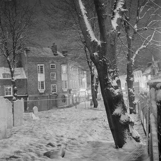 The graveyard of Highgate School Chapel covered in snow, 1971; looking towards the junction of Southwood Lane and Highgate High Street. The cast-iron railings surrounding this portion of the graveyard date from the early 19th century.