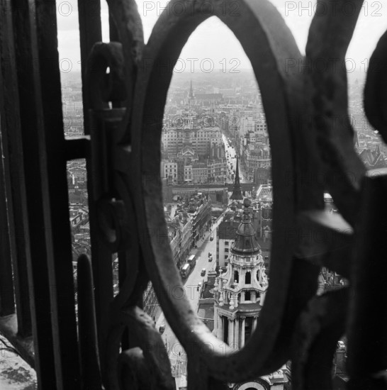 View through the decorative iron railings of the Golden Gallery at St Paul's Cathedral, looking east over Ludgate Hill and Fleet Street, London, 1960-1970.