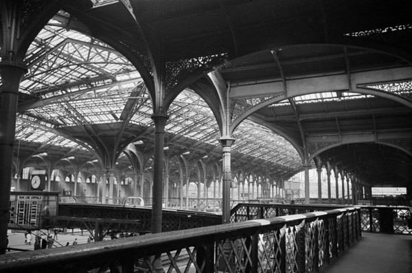 The interior of Liverpool Street Station showing the footbridge over the Continental Boat Train arrival platform and the ornate cast iron roof structure, London, 1960-1972.