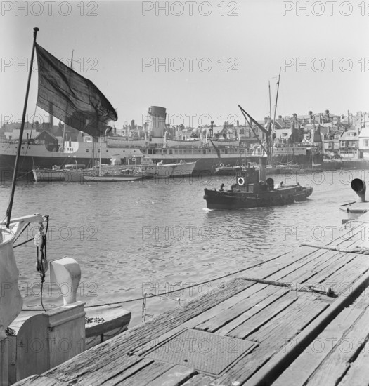 A view of the harbour at Weymouth showing various vessels including SS St Julien, 1948. This image seems to be part of a batch that were taken in preparation for a Laing staff outing to Weymouth, which was to take place on 5th June the following month. The images were published in a pamphlet which detailed the programme for the day including travel arrangements, catering and afternoon activities. The pamphlet also celebrates the fact this outing is taking place in Laing's Centenary Year, with a page dedicated to the history of the firm and another with a message from J. W. Laing.