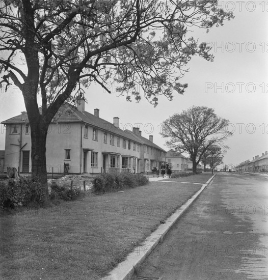 A view looking down a street of Easiform housing in Grimsby, Loncolnshire, 1948. 'Easiform' was a method of in situ pre-cast concrete construction which John Laing and Son Ltd developed from 1919 onwards. The location of this Easiform estate is not known, however it is recorded as Grimsby No.1 in the negative registers.