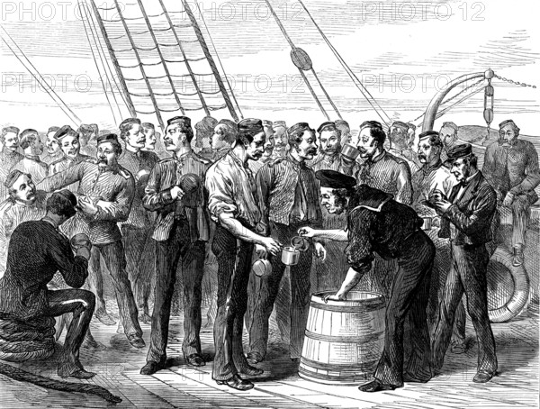 Life on board a troop-ship: serving out grog, 1873. 'Major W. O. Carlile's sketches of life on board a troopship, though not actually taken, upon this occasion, from the transports now engaged in carrying our soldiers to West Africa, have yet a special interest at the present time. The regulations and habits of daily experience in such voyages were detailed in our former notices. For the prevention of irregularities and excess in drink, and for the preservation of health, the men are subjected to very stringent rules; and it is the duty of their officers to see these rules enforced. A gill of rum, mixed with two gills of water, is given to each man after dinner. He must either drink it at once, or leave it, when it is thrown overboard'. From "Illustrated London News", 1873.