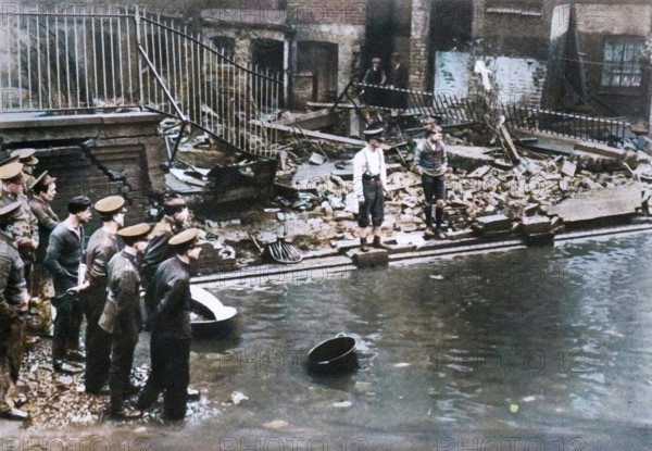 Flooding in London, 1928, (1935). 'Fourteen people were drowned as they slept in basement near the river and much damage was done to the surrounding property'. Flood waters poured over the top of the Thames Embankment and part of the Chelsea Embankment collapsed during the 1928 Thames flood. From "The Silver Jubilee Book - The Story of 25 Eventful Years in Pictures". [Odhams Press Ltd., London, 1935]. (Colorised black and white print).