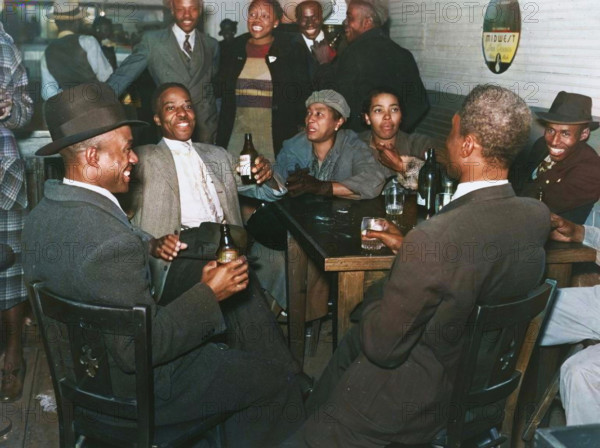 African Americans conversing and drinking beers in a bar, Clarksdale, Mississippi Delta, November 1939. (Colorised black and white print).