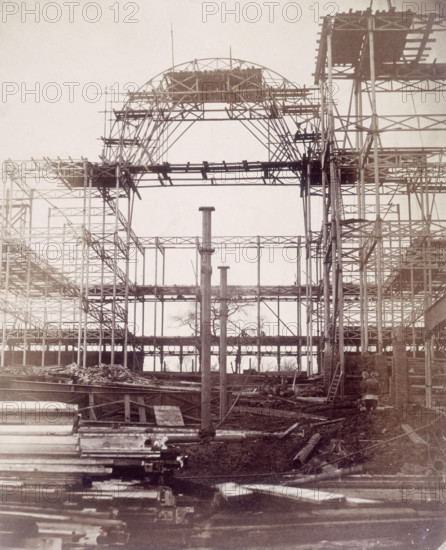 'First rib of the Nave, October 1852', Crystal Palace, London. Designed by Sir Joseph Paxton to house the Great Exhibition of 1851 in Hyde Park, the Crystal Palace was reconstructed and enlarged in Sydenham in 1852. The first column was raised on 5 August 1852 and the palace was opened by Queen Victoria on 10 June 1854. Many exhibitions and events were subsequently held at the Crystal Palace until it burnt down on 30 November 1936. The park contained a motor racing circuit from 1937 until 1972 and the famous athletics track dates back to the foundation of the Crystal Palace Athletics Club in 1868. Plate 5 from "Photographic Views of the Progress of the Crystal Palace, Sydenham. Taken during the progress of the works, by desire of the directors, by Philip H Delamotte. Together with a list of the directors and officers of the company, etc". [London, 1855].