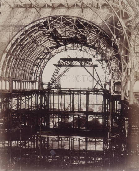 'South Transept looking towards Penge', Crystal Palace, Sydenham, 1852-1854. Designed by Sir Joseph Paxton to house the Great Exhibition of 1851 in Hyde Park, the Crystal Palace was reconstructed and enlarged in Sydenham in 1852. The first column was raised on 5 August 1852 and the palace was opened by Queen Victoria on 10 June 1854. Many exhibitions and events were subsequently held at the Crystal Palace until it burnt down on 30 November 1936. The park contained a motor racing circuit from 1937 until 1972 and the famous athletics track dates back to the foundation of the Crystal Palace Athletics Club in 1868. Plate 18 from "Photographic Views of the Progress of the Crystal Palace, Sydenham. Taken during the progress of the works, by desire of the directors, by Philip H Delamotte. Together with a list of the directors and officers of the company, etc". [London, 1855].