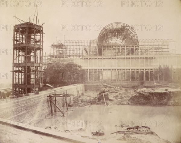 'The North end of the Building from the Reservoir', Crystal Palace, Sydenham, 1852-1854. Designed by Sir Joseph Paxton to house the Great Exhibition of 1851 in Hyde Park, the Crystal Palace was reconstructed and enlarged in Sydenham in 1852. The first column was raised on 5 August 1852 and the palace was opened by Queen Victoria on 10 June 1854. Many exhibitions and events were subsequently held at the Crystal Palace until it burnt down on 30 November 1936. The park contained a motor racing circuit from 1937 until 1972 and the famous athletics track dates back to the foundation of the Crystal Palace Athletics Club in 1868. Plate 20 from "Photographic Views of the Progress of the Crystal Palace, Sydenham. Taken during the progress of the works, by desire of the directors, by Philip H Delamotte. Together with a list of the directors and officers of the company, etc". [London, 1855].