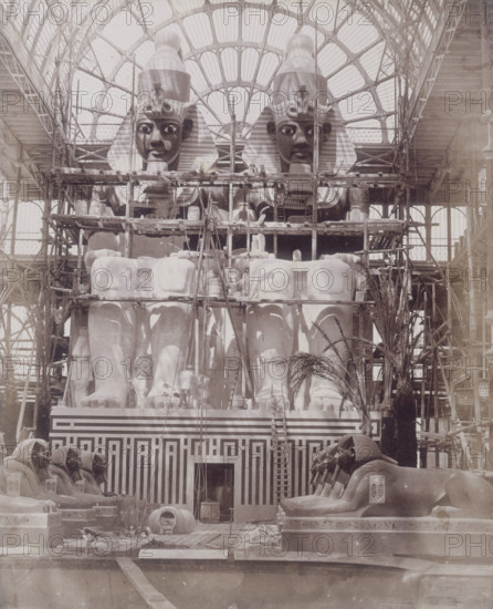 'The Colossi of Aboo Simbel in Process of Painting', Crystal Palace, Sydenham, 1852-1854. Designed by Sir Joseph Paxton to house the Great Exhibition of 1851 in Hyde Park, the Crystal Palace was reconstructed and enlarged in Sydenham in 1852. The first column was raised on 5 August 1852 and the palace was opened by Queen Victoria on 10 June 1854. Many exhibitions and events were subsequently held at the Crystal Palace until it burnt down on 30 November 1936. The park contained a motor racing circuit from 1937 until 1972 and the famous athletics track dates back to the foundation of the Crystal Palace Athletics Club in 1868. Plate 64 from "Photographic Views of the Progress of the Crystal Palace, Sydenham. Taken during the progress of the works, by desire of the directors, by Philip H Delamotte. Together with a list of the directors and officers of the company, etc". [London, 1855].
