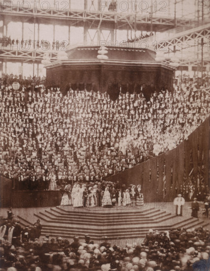 'The Opening Ceremony', Crystal Palace, Sydenham, 1852-1854. Designed by Sir Joseph Paxton to house the Great Exhibition of 1851 in Hyde Park, the Crystal Palace was reconstructed and enlarged in Sydenham in 1852. The first column was raised on 5 August 1852 and the palace was opened by Queen Victoria on 10 June 1854. Many exhibitions and events were subsequently held at the Crystal Palace until it burnt down on 30 November 1936. The park contained a motor racing circuit from 1937 until 1972 and the famous athletics track dates back to the foundation of the Crystal Palace Athletics Club in 1868. Plate 99 from "Photographic Views of the Progress of the Crystal Palace, Sydenham. Taken during the progress of the works, by desire of the directors, by Philip H Delamotte. Together with a list of the directors and officers of the company, etc". [London, 1855].