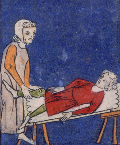 A woman setting a bone in a boy's leg, 14th century. The boy lies back on a table while the woman sets the bone in place.