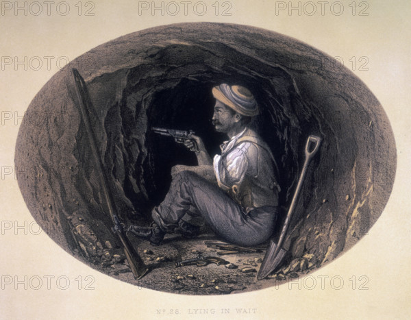 'Lying in Wait', 1858. A man armed with a pistol, sitting on the ground in what appears to be a tunnel. Another pistol lies on the ground next to him, and a rifle and a shovel are resting against the walls. From "Sketches and Incidents of the Siege of Lucknow, from Drawings made during the Siege", by George Couper.