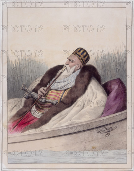 Ali Tebelen, Pacha de Janina, 1819. Ali Pasha (1741-1822) reclining in a boat smoking a pipe, and wearing a coat trimmed with fur. In 1787 he became the Turkish pasha (military governor) of Yannina, which is now Ioánnina in Greece, but was a province of the Ottoman Empire. He was called the lion of Yannina because of his harsh rule. From "Voyage à Athènes et à constantinople; ou collection de portraits, vues et costumes Grecs et Ottomans".