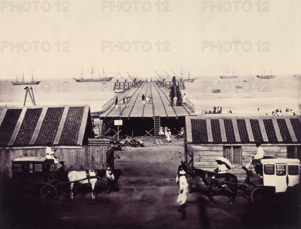The Pier under construction, Madras, India, c1861. A view of the works from the foreshore, looking straight along the pier. 'Screw Pile Pier Works - No admittance except on Business'. Screw piles are a steel screw-in piling and ground anchoring system used for building deep foundations. The pier was designed by Alexander Mitchell. From "Construction Of The Screw-Pile Pier At Madras".