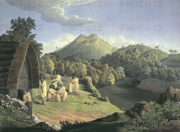 A Toda family in the Nilgiri Hills, India, 1837. Alternative title: 'The Nilgiri Sannyasis'. 'Taken at Kandelmund, which it represents, and the Toda family inhabiting'. Group of people sitting outside a wooden building. The Todas are believed by some to be descendants of Romans, a lost tribe of Israel, or even the descendants of Alexander the Great's soldiers. Plate 5 from Richard Barron's "View in India, chiefly among the Neelgherry Hills".