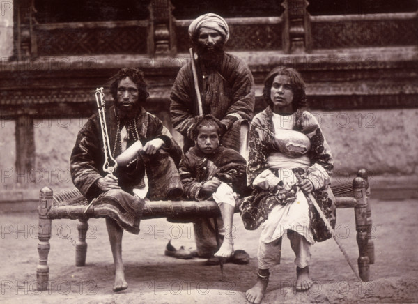 Group of beggars sitting on a charpoy, Kabul, Afghanistan, c1880.