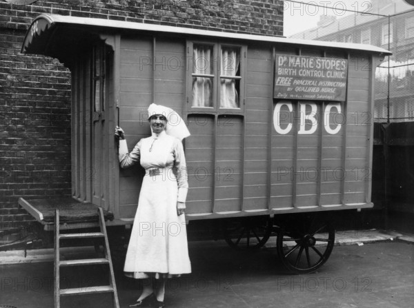 Nurse outside a Marie Stopes mobile birth control clinic, Bethnal Green, London, 1928. 'Free practical instruction by qualified nurse'. In 1921, Dr Marie Stopes founded the first birth control clinic in Britain. In order to make advice on birth control available in working class areas and rural districts, Dr Stopes also established mobile clinics in caravans, such as this one. However Stopes' ideas about eugenics were controversial: according to some she was 'an elitist, an idealist, interested in creating a society in which only the best and beautiful should survive'.