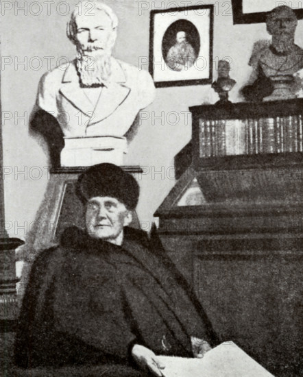 Mme Dostoevsky at work in the Dostoevsky room of the Moscow Historical Museum (taken during her last visit there), 1916. Anna Dostoyevskaya (1846-1918) was a Russian writer, philatelist, memoirist and stenographer in her own right, as well as assistant and wife of Fyodor Mikhaylovich Dostoyevsky. She was also one of the first female philatelists in Russia. Behind her are portrait busts of her husband. From "Dostoevsky Portrayed by his Wife" by Mme Dostoevsky. Translated from the Russian and edited by S S Koteliansky. [London, 1926].