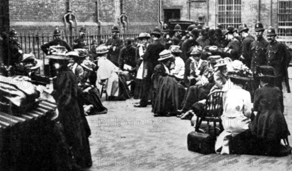 Awaiting their turn in the Police Yard at Bow Street, London, 30 June 1909. Suffragettes were arrested on a charge of 'Wilful Damage'. From "The Suffragette Movement. An intimate account of persons and ideals" by E Sylvia Pankhurst. [1931].