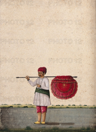 An Indian bearer holding a large, richly decorated fan or banner..., (between 1800 and 1899?). Creator: Unknown.