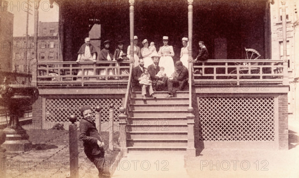Bellevue Hospital, New York City: children patients, nurses and doctors sitting on a balcony in... Creator: Unknown.