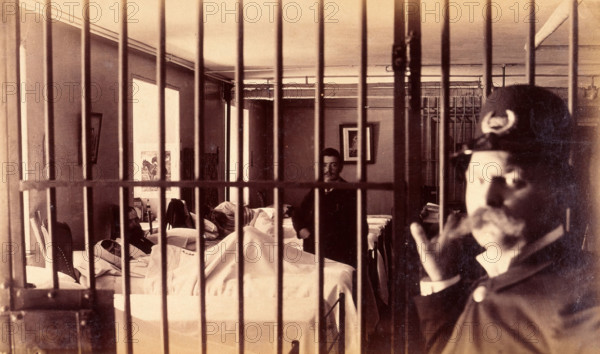 Bellevue Hospital, New York City: male patients (criminal insane?) in bed in ward, prison bars in... Creator: Unknown.