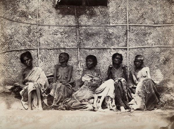 Famine in Mysore, India: six emaciated women, five sitting and one leaning on another's lap, 1876-78 Creator: Willoughby Wallace Hooper.