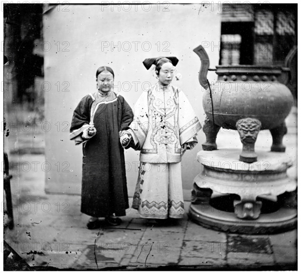 China: a Manchu woman with her maid standing beside a bronze burner, Beijing, 1869. Creator: John Thomson.