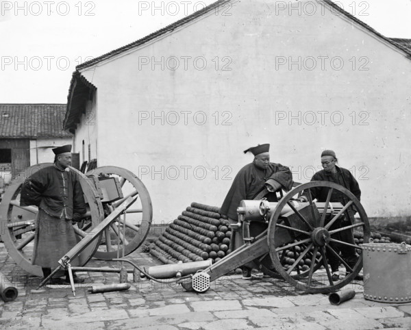 Nanking, Kiangsu province, China: three men examining a gun at the arsenal, 1871. Creator: John Thomson.