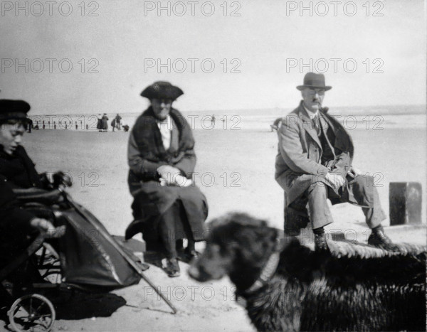 A physically disabled boy sitting in a wheelchair on a beach,  c1910/1925. Creator: Unknown.